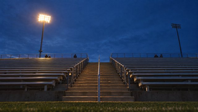 The stadium stair at dusk, the first floodlight on