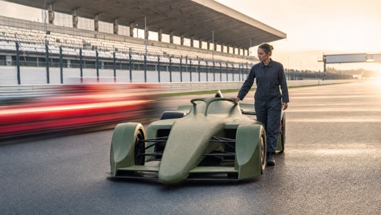 A pale green race car at a crawl on the track, a rival streaked past as a red blur, a mechanic walking alongside